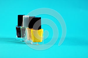 Group of nail polish bottles, blue background, free copy space