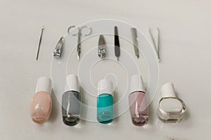 Group of nail polish of different colors and nail accessories in white marble