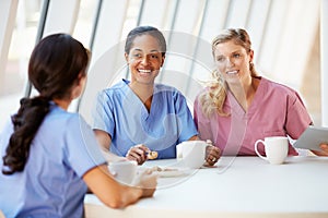 Group Of Nurses Chatting In Modern Hospital Canteen photo