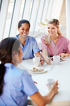 Group Of Nurses Chatting In Modern Hospital Canteen photo