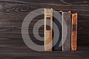 Group of old hardcover books on a dark wooden background
