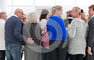 A group of old people standing with their backs indoors