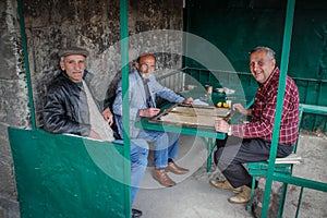 A group of older men are relaxing playing backgammon