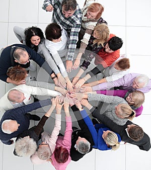 group of older people joining their palms together.
