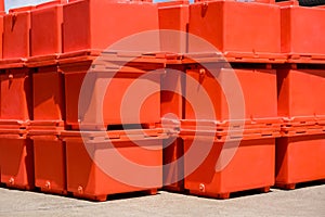 Group of orange foldable ice buckets stack on courtyard outside of storage