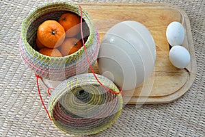 Group of oranges in bamboo container with duck egg and ostrich e