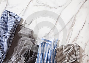 Group of organic cotton pyjamas set on white marble table is ready for folding and placing into white steel wire mesh