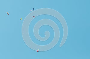 A group of parachutists in a clear sky with colored bright parachutes.