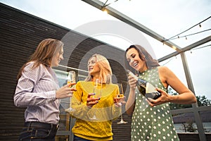 Group of partying girls with flutes with sparkling wine having fun