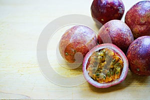 Group of passion fruit with half cut on wooden table with blur green garden background, copy space, healthy food concept