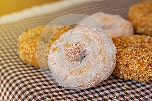 The group of peanut donut and coconut donut on the tablecloth in the natural light on the table by close up style.