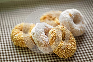 The group of peanut donut and coconut donut on the tablecloth in the natural light on the table by close up style.