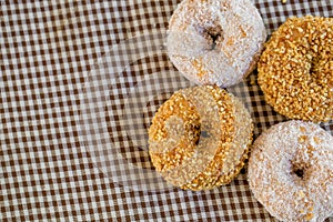 The group of peanut donut and coconut donut on the tablecloth in the natural light on the table by close up style.