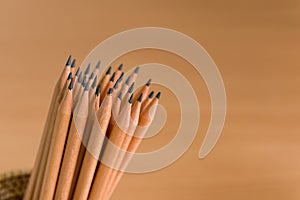 Group of pencils standing on brown background