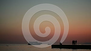 Group of people on a background of the sea. silhouettes at sunset. summer beach