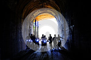 Group of People Biking Through Tunnel with Headlights Hiawatha Trail