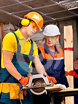 Group people builder with circular saw .