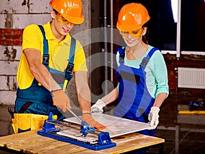 Group people builder cutting ceramic tile