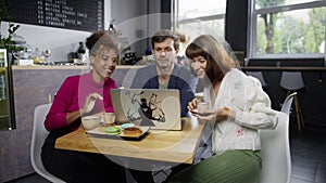 A group of people in a cafe at an online business meeting over coffee.