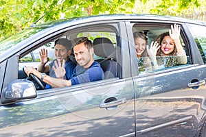 Group of people in the car waving hands