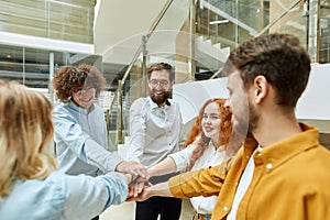 Group of people in casual clothes hands in union sign