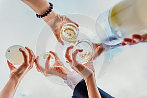 Group of people celebrating a success with drinks offering their drinks