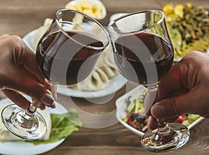 group of people clinking glasses with wine in front