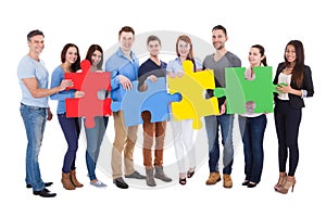 Group of people connecting puzzle pieces