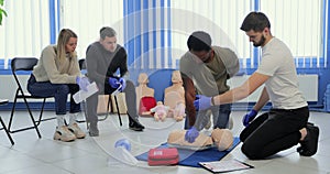 Group of people CPR First Aid Training course. CPR teen dummy first aid training.