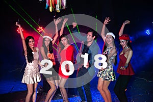 Group of people dancing at night club with Santa hat Christmas holidays party.