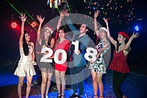 Group of people dancing at night club with Santa hat Christmas holidays party.