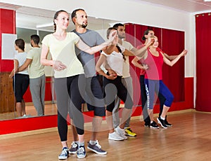 Group of people dancing salsa in studio