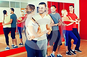 Group of people dancing salsa in studio