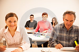 Group of people of different age sitting in classroom and attend