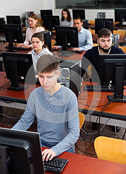 Group of people of different ages learning to use computers in classroom