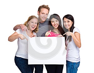 Group of people with diverse ethnicities holding blank sign for