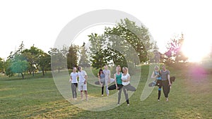 A group of people do yoga in the Park at sunset. Healthy lifestyle, meditation and Wellness