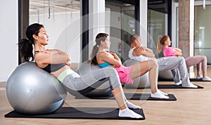 Group of people doing crunches on swiss balls