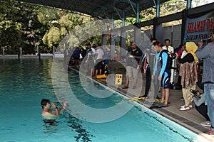 A group of people doing diving training in a swimming pool