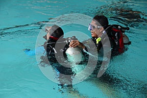 A group of people doing diving training in a swimming pool