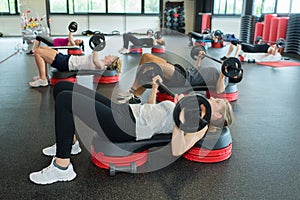 Group people doing fitness exercising in gym together