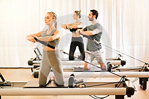 Group of people doing pilates torsion rotation exercises photo