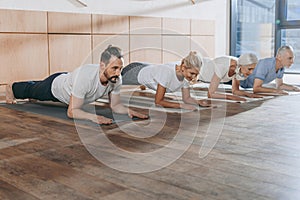 group of people doing plank on yoga mats
