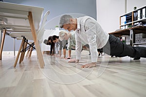 Group Of People Doing Pushups At Work