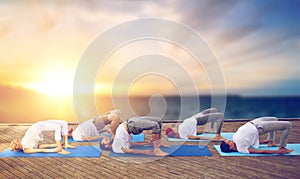 Group of people doing yoga bridge pose outdoors