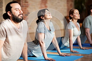 Group of people doing yoga dog pose at studio