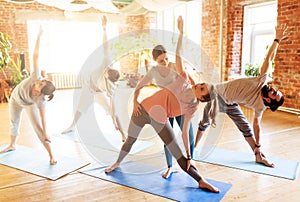 group of people doing yoga exercises at studio