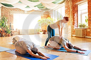 group of people doing yoga exercises at studio