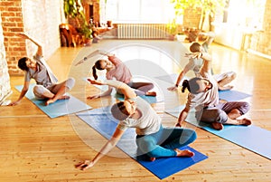 group of people doing yoga exercises at studio