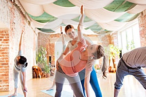 Group of people doing yoga exercises at studio